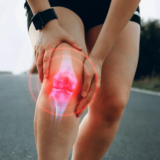 Osoba drži koljeno, preko kojega je prikazan grafički prikaz koljenskog zgloba s crvenim naglaskom.