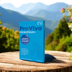 Kutija dodatka prehrani ProVivo Probiotikum+ brenda Swiss Blanc, postavljena na drvenu površinu u prirodnom planinskom okruženju.